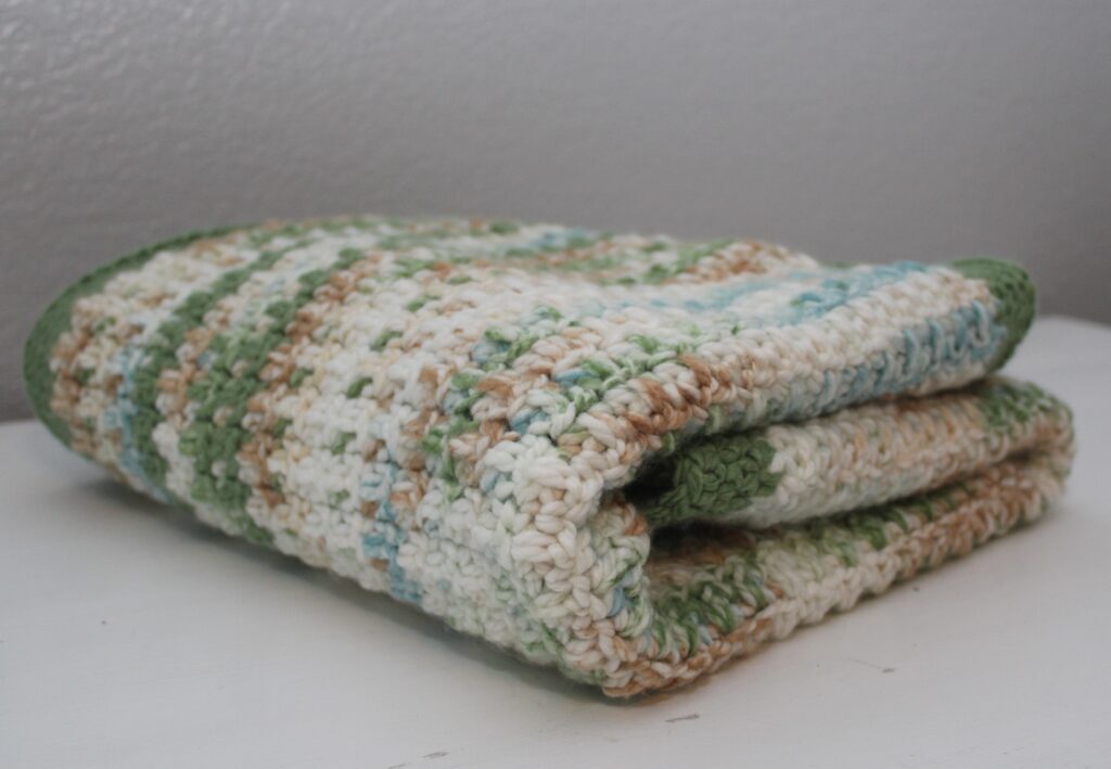 Warm Woodlands themed baby blanket folded on a dresser
