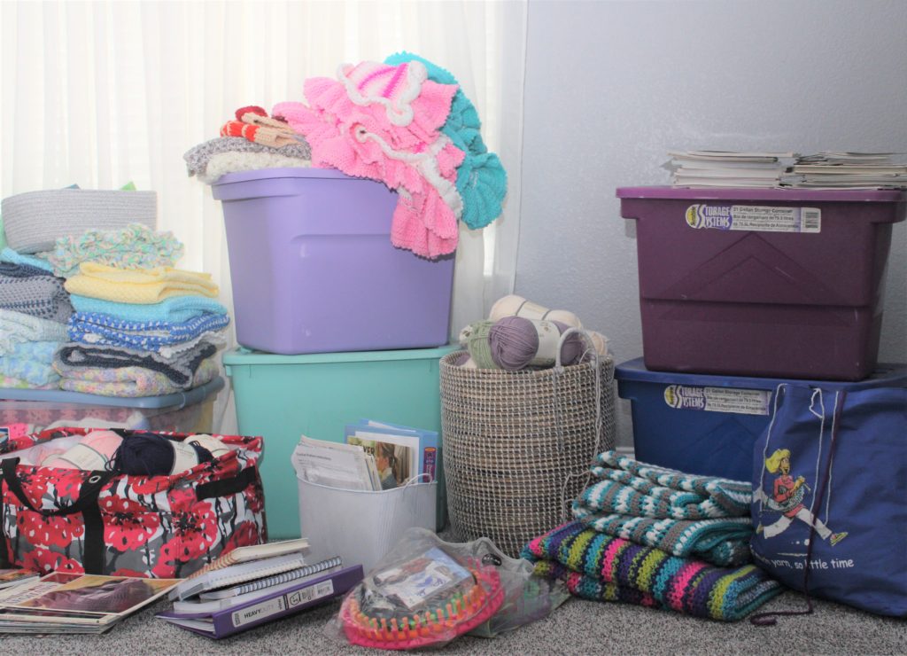 piles of yarn, boxes, books, bags