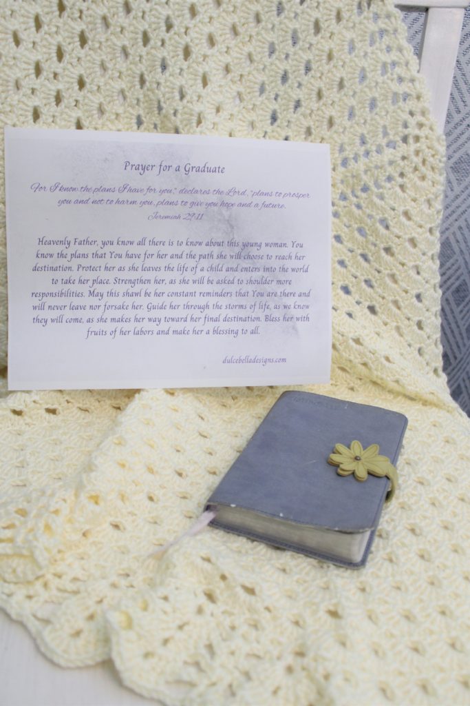 yellow shawl draped onto a chair with a Bible and prayer on top