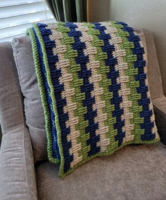 green, blue, and ivory afghan draped on a chair