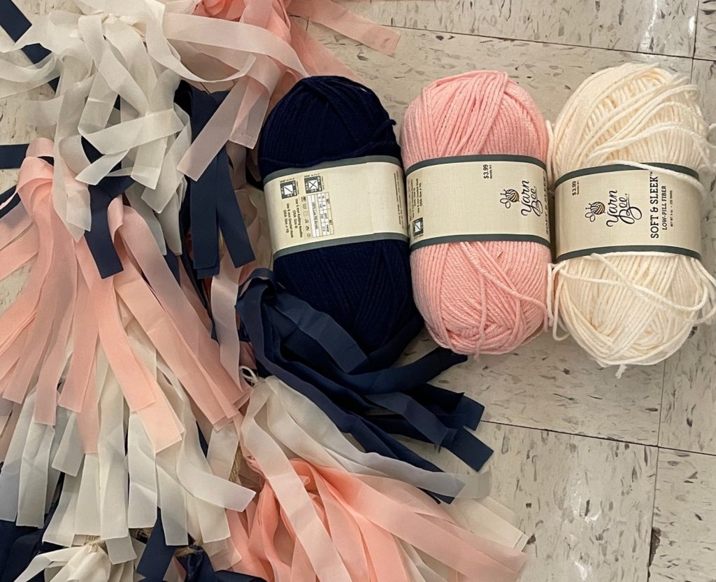 pink and blue streamers beside pink, blue, and ivory yarn