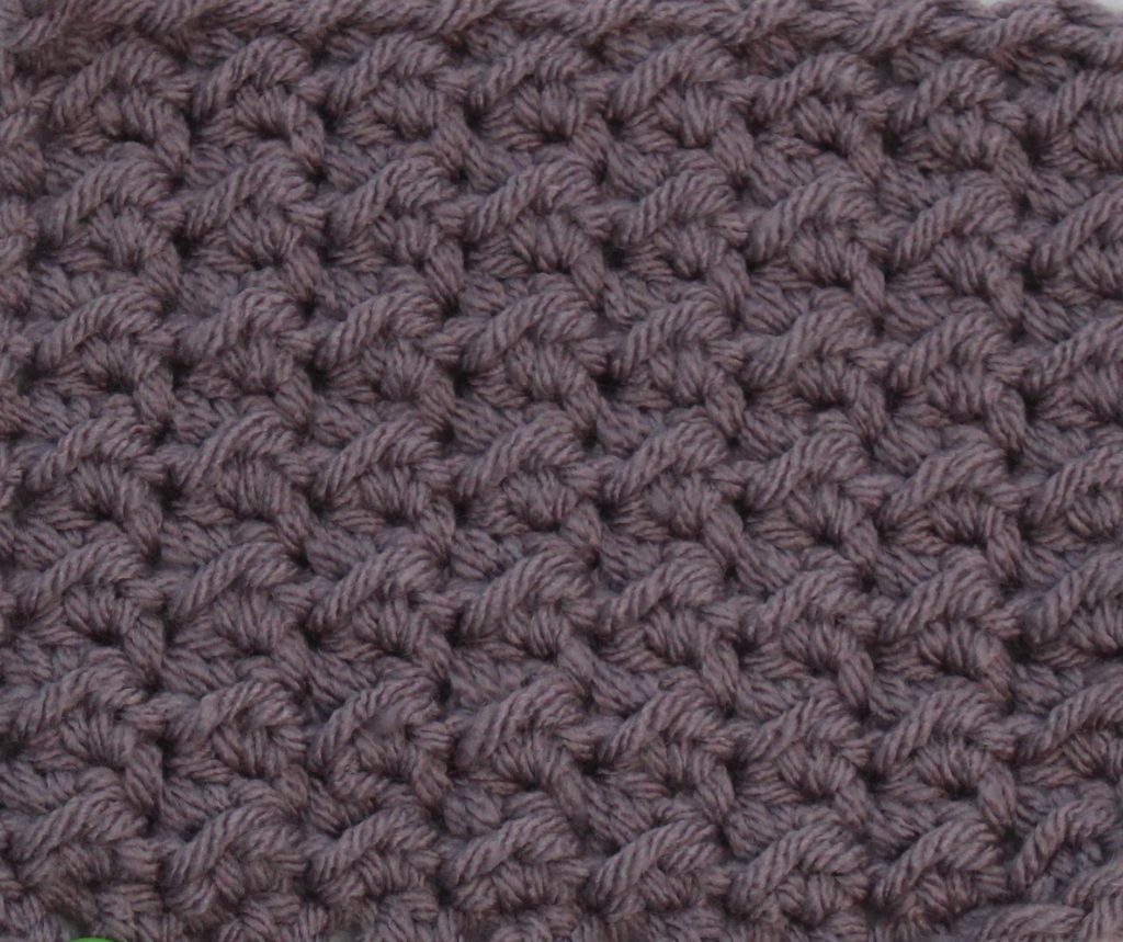 purple crochet swatch showing the even moss stitch