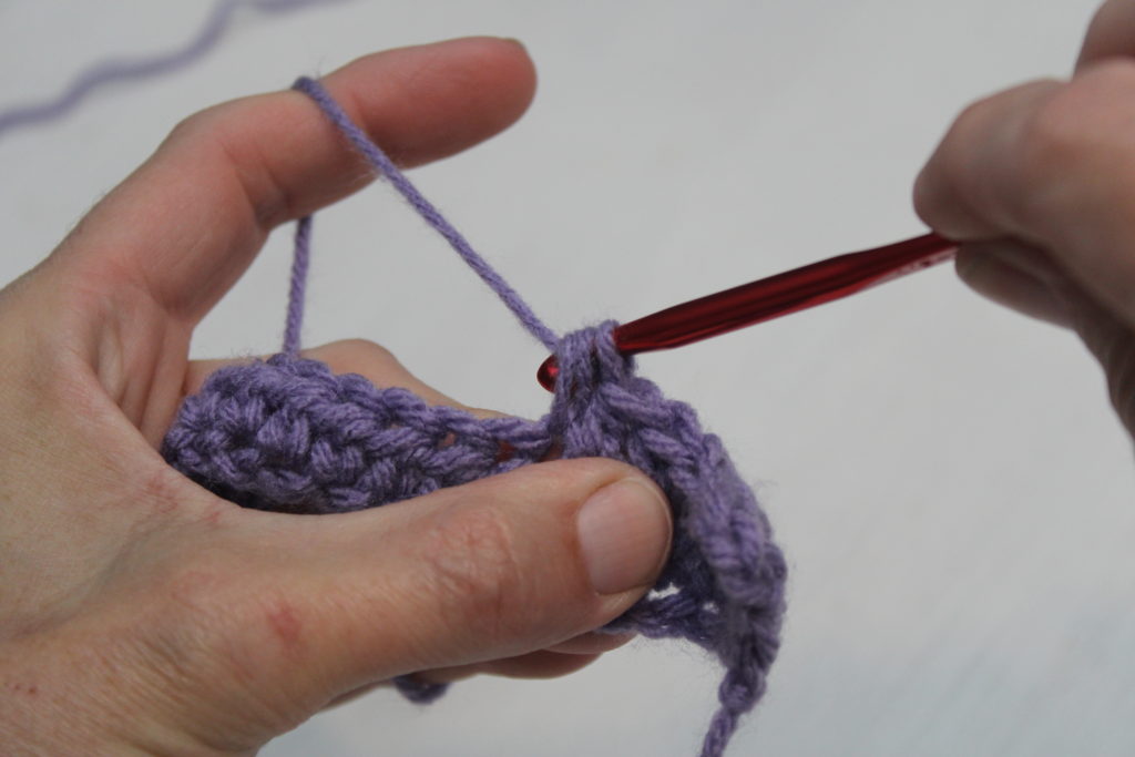 half double crochet step 3 pulling through three loops on hook