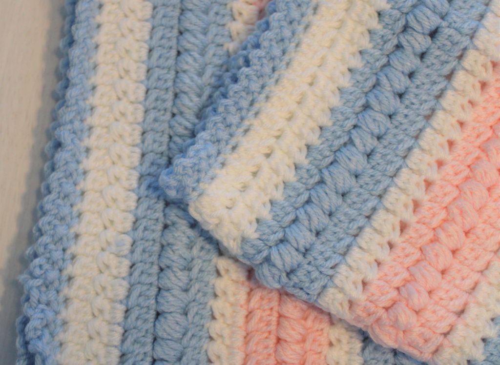 blue, white and pink afghan up close to show border and texture