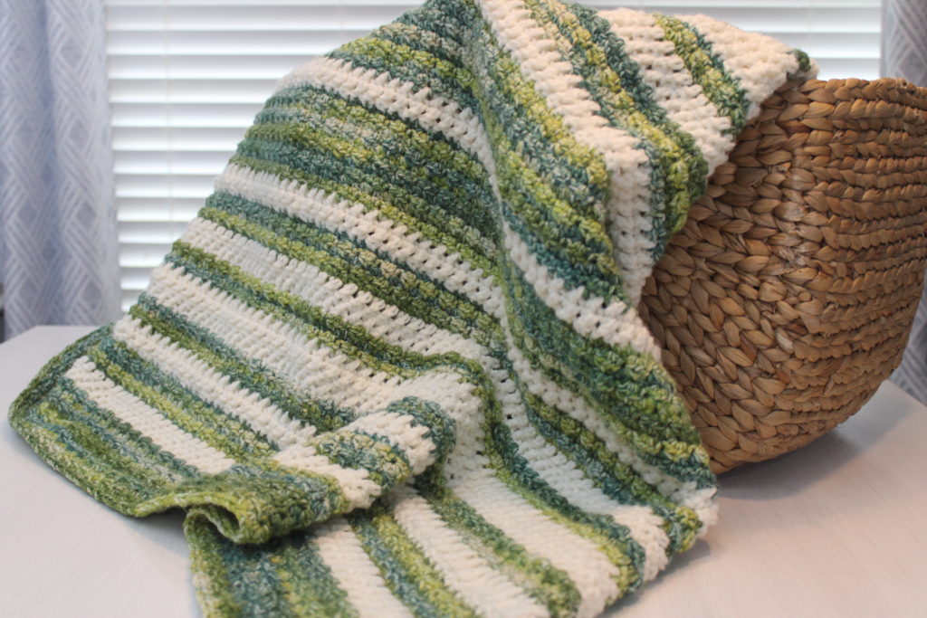 Wintergreen throw in Green and Ivory Wintergreen Crochet Throw in a basket