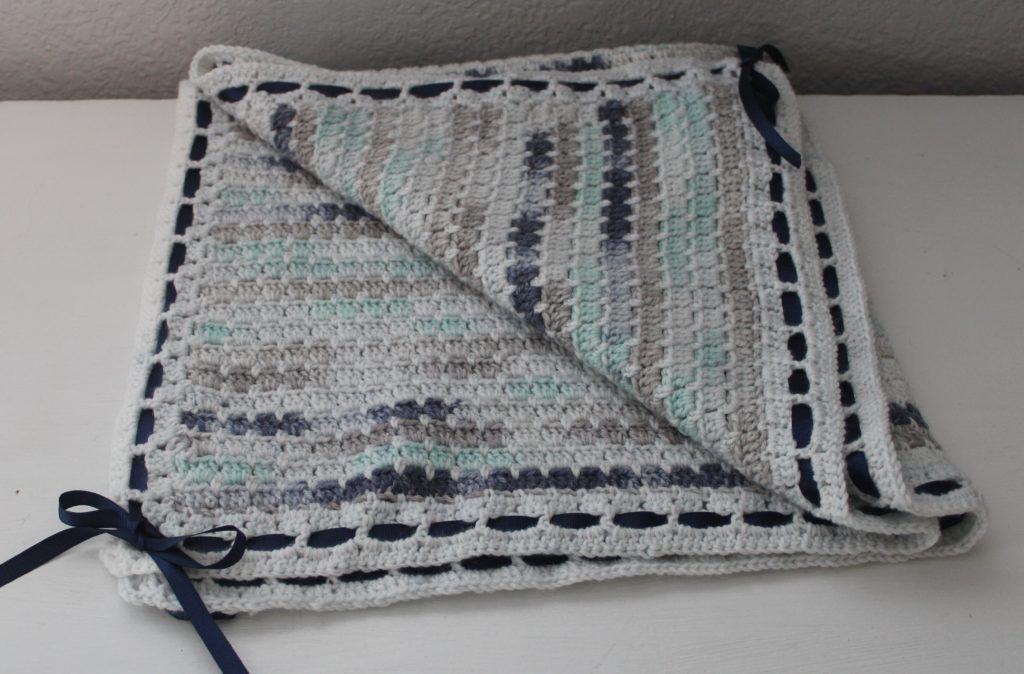 Little Boy Blue baby blanket in blue, white, green, and grey folded baby afghan 
