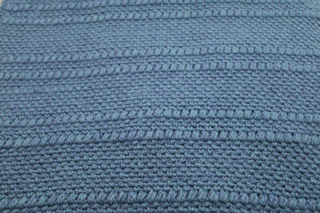 Moss stitch and small puff stitch pattern up close in blue