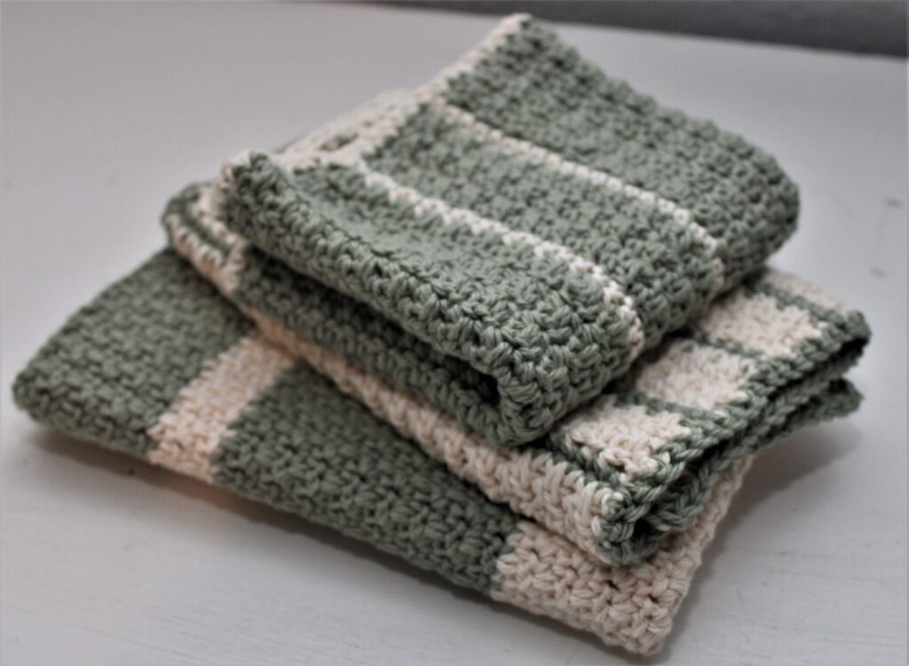 green and ivory woodland themed burb cloths folded and stacked
